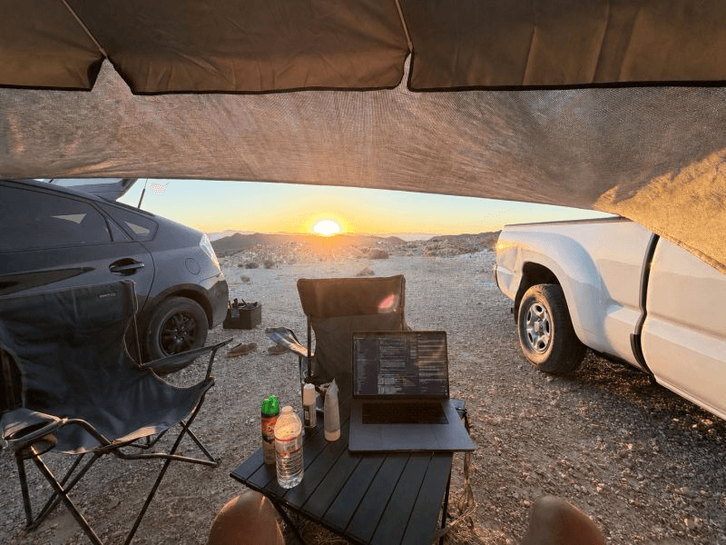 A MacBook running at a field camp on BLM land in Nevada at sunset, where Carl began the work that led to Jolene AI